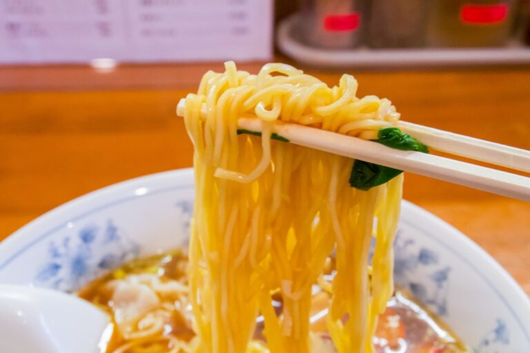 Bowl of Japanese noodles with chopsticks showcasing soy sauce seasoning
