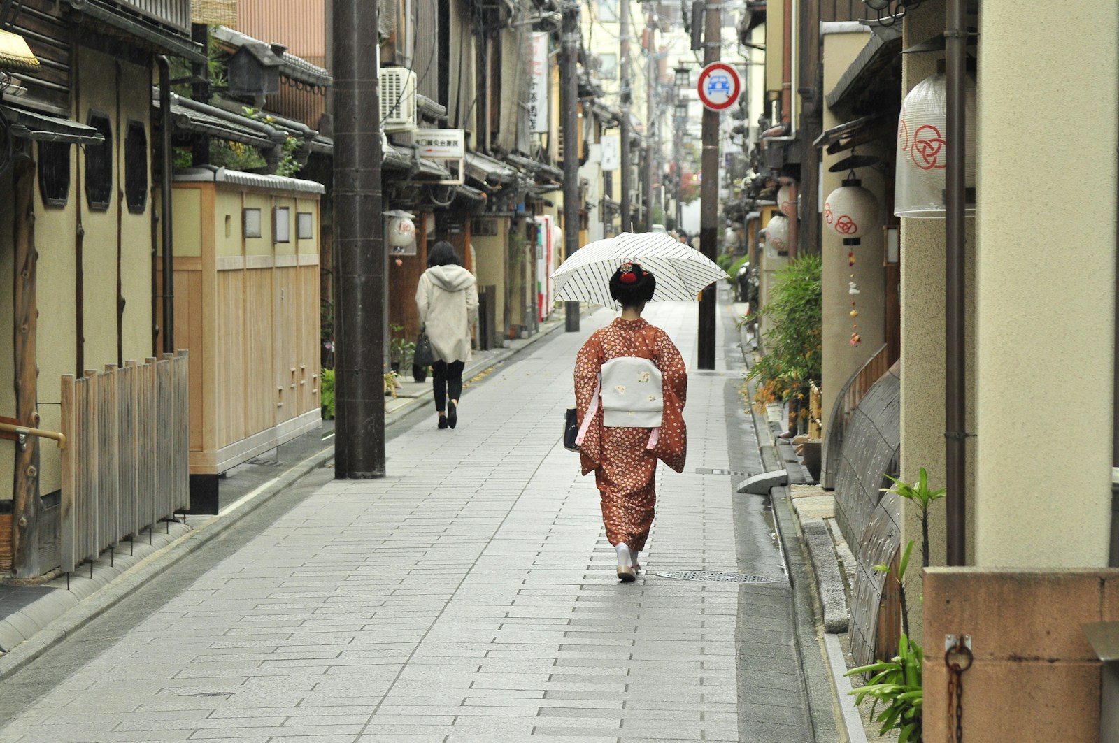 Nhân viên cửa hàng đang mặc kimono cho khách du lịch Việt Nam tại Kyoto với quy trình chuyên nghiệp