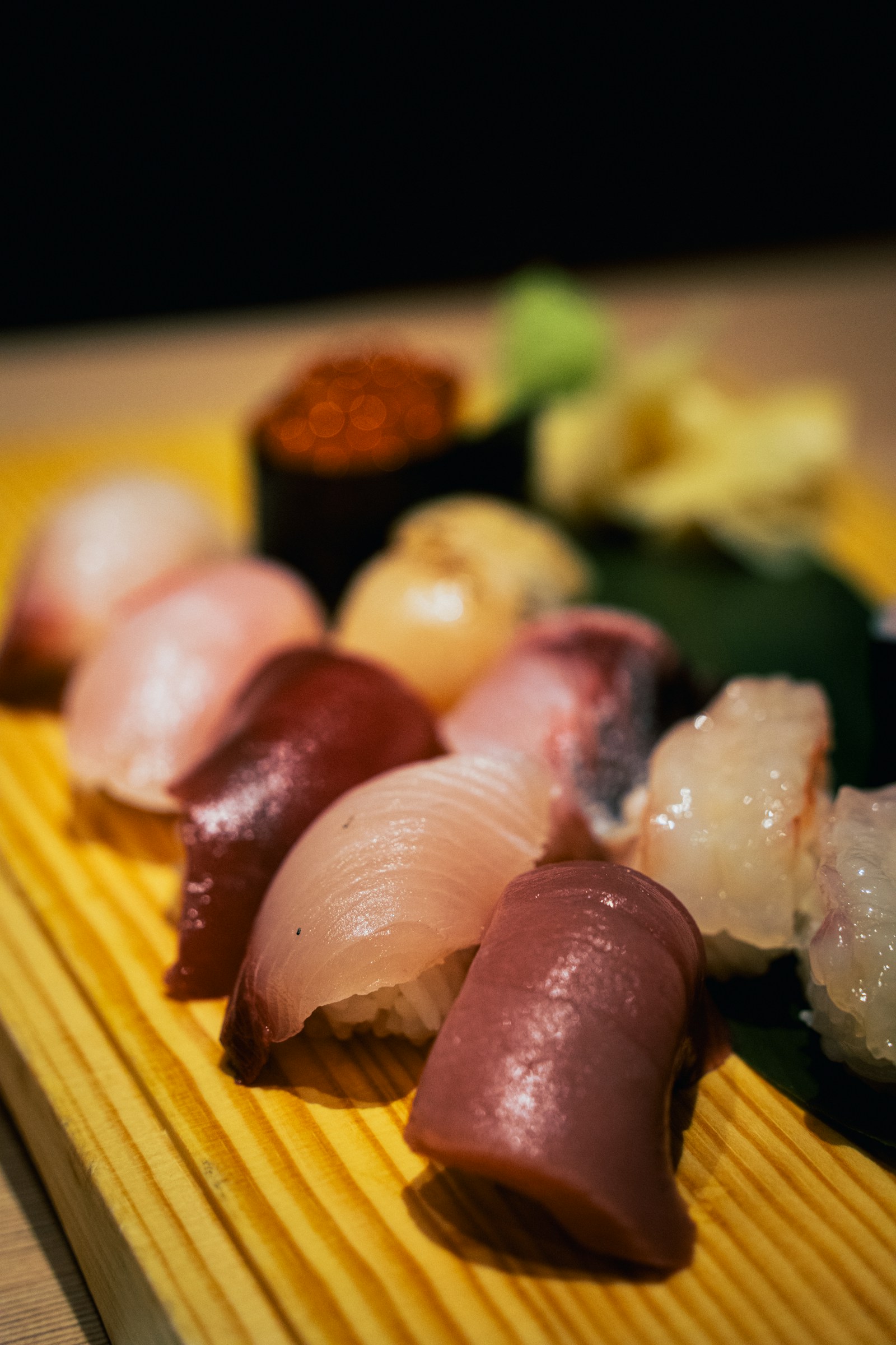 Cận cảnh sushi đa dạng với wasabi xanh và gừng ngâm hồng