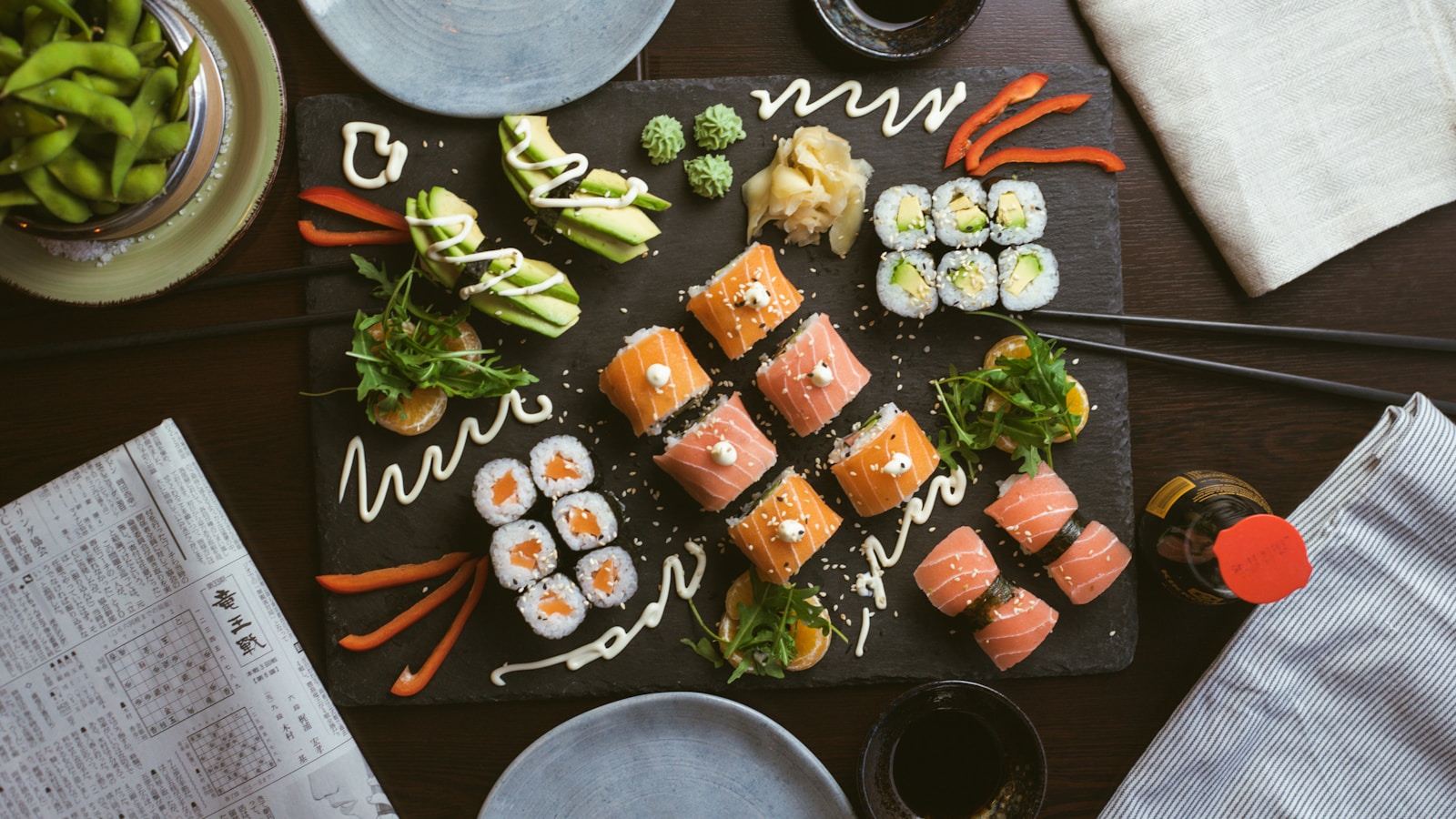 Sushi Nigiri trên đĩa gốm đen sang trọng với wasabi và gừng ngâm