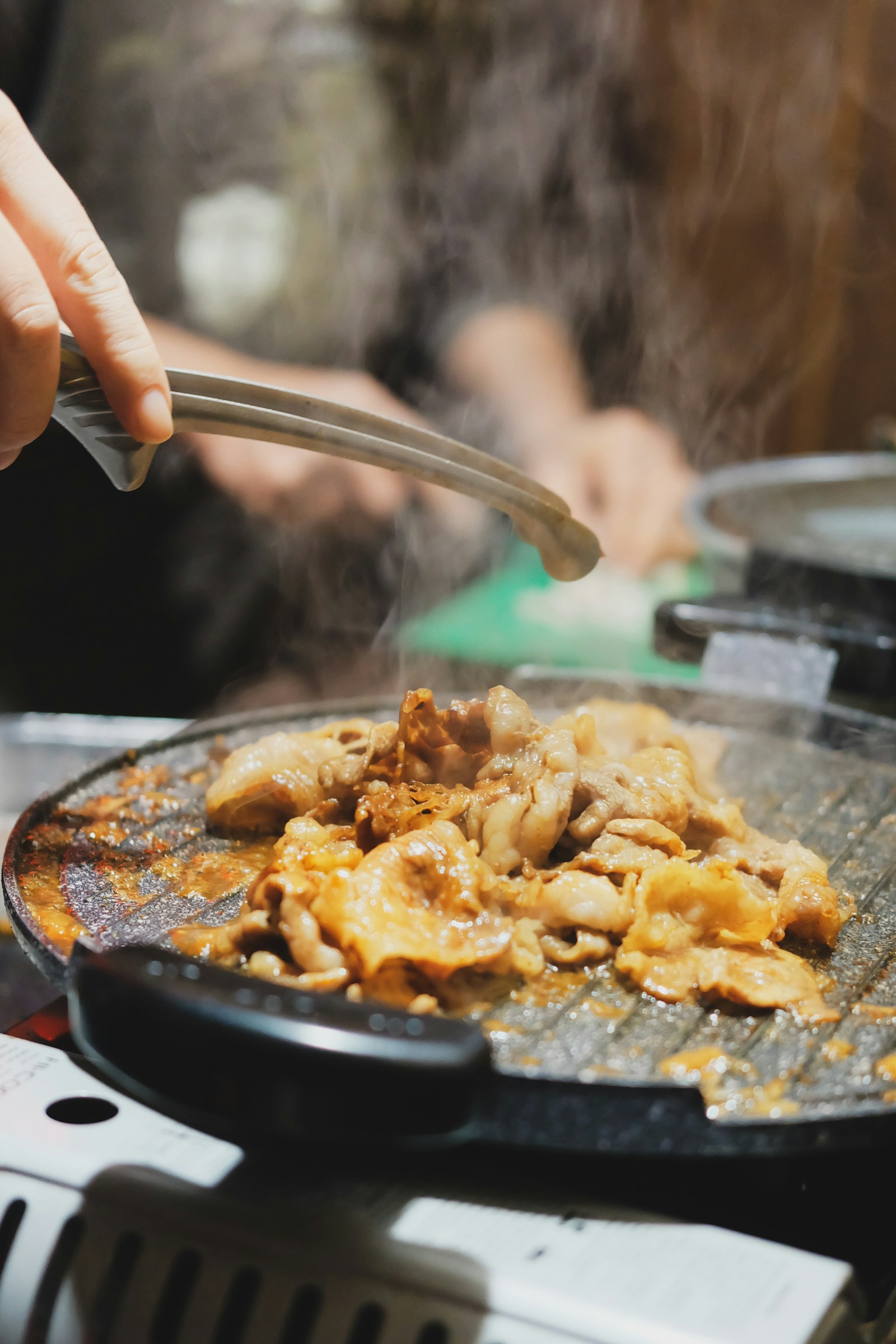 Bếp nướng yakiniku sizzling với khói thơm tại nhà hàng Nhật Bản